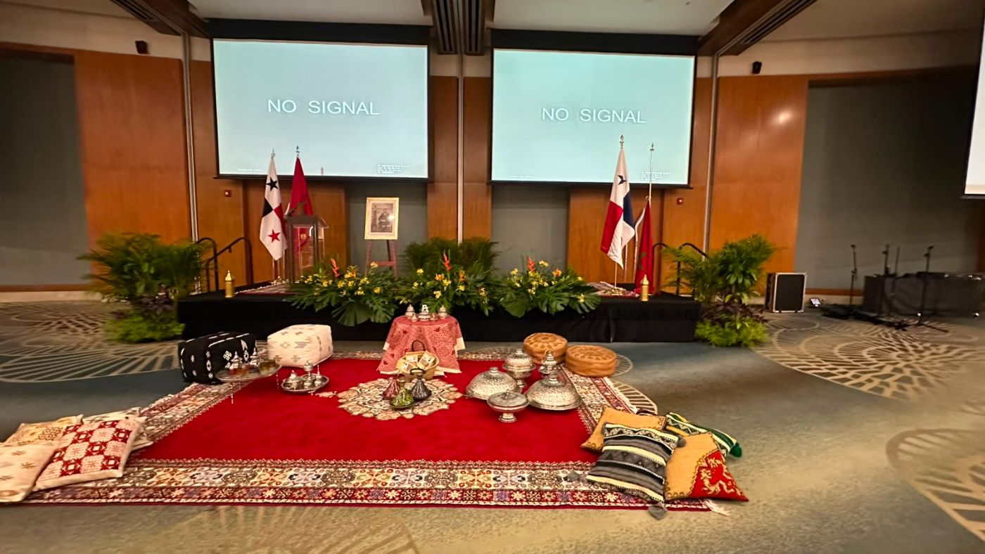 Tarima de un evento protocolar decorada con heliconias, palmas y follaje tropical